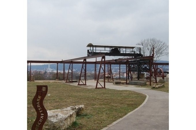 Alte Industrieanlage im Travertinpark, umgeben von Wiesen und einem Weg. Im Hintergrund ist eine Stadtlandschaft zu sehen., © Cool-Tours StattReisen Alte Industrieanlage im Travertinpark, umgeben von Wiesen und einem Weg. Im Hintergrund ist eine Stadtlandschaft zu sehen., © Cool-Tours StattReisen