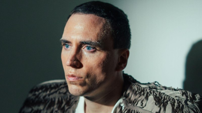 Ein Mann mit kurzem Haar und einem strukturierten Oberteil blickt ernst zur Seite. Die Beleuchtung erzeugt einen dramatischen Schatteneffekt., &copy; Konzertb&uuml;ro Leipzig