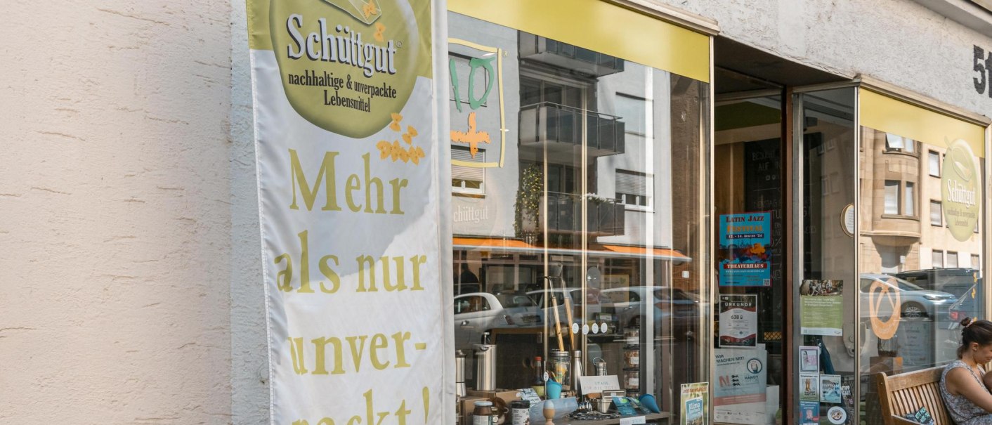 Ein Laden namens 'Schüttgut' bietet nachhaltige und unverpackte Lebensmittel an. Ein Banner wirbt mit 'Mehr als nur unverpackt!'., © SMG, Sarah Schmid