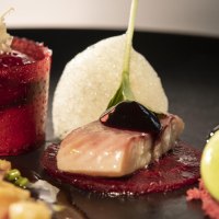 Ein kunstvoll angerichtetes Gourmetgericht mit rotem Gelee, Fisch und gr&uuml;ner Creme auf einem schwarzen Teller., &copy; Restaurant Bachofer