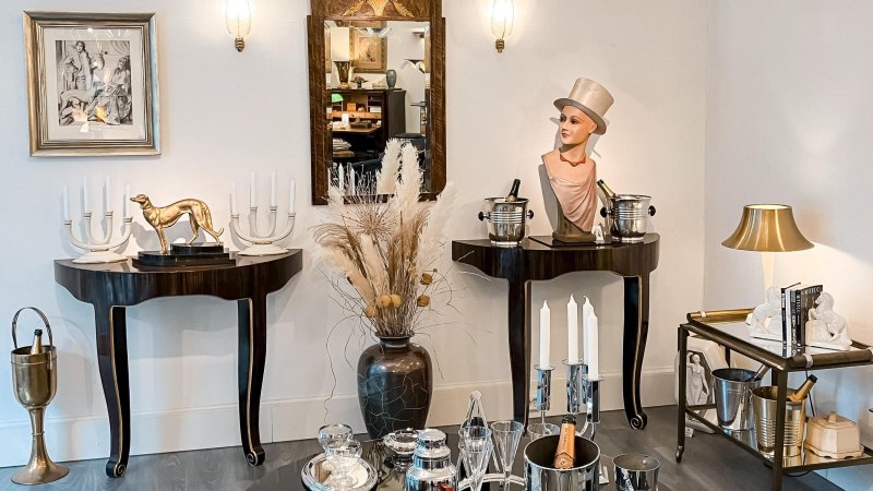 Elegante Einrichtung mit Büste, goldener Hundeskulptur, Kerzenhaltern und Spiegel. Dekorative Elemente auf Tischen und Regalen., © Metropolis Art Deco, Stuttgart Elegante Einrichtung mit Büste, goldener Hundeskulptur, Kerzenhaltern und Spiegel. Dekorative Elemente auf Tischen und Regalen., © Metropolis Art Deco, Stuttgart