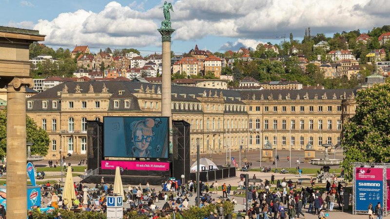 People gather in front of a large screen on Schlossplatz in Stuttgart. The New Palace can be seen in the background., © SMG, Sarah Schmid People gather in front of a large screen on Schlossplatz in Stuttgart. The New Palace can be seen in the background., © SMG, Sarah Schmid