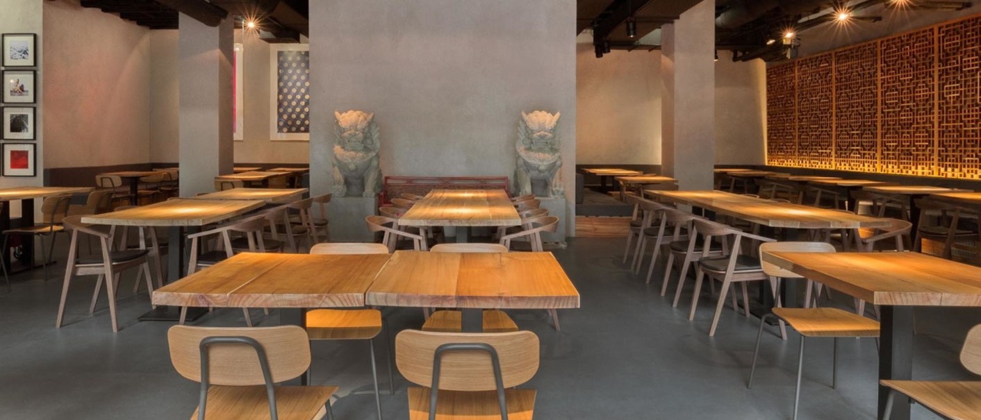 Modern restaurant with wooden tables, chairs and Asian decorations. Subtle lighting and artistic wall design create an inviting atmosphere., © Breitengrad17, Stuttgart