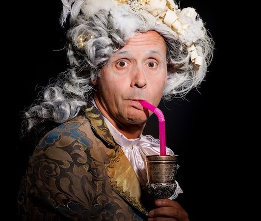 Person in barocker Kleidung mit Perücke und Federhut trinkt aus einem Becher mit Strohhalm., © Renitenztheater Stuttgart e.V. Person in barocker Kleidung mit Perücke und Federhut trinkt aus einem Becher mit Strohhalm., © Renitenztheater Stuttgart e.V.