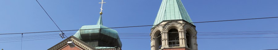 Two steeples of the Russian church of St. Nicholas with blue roofs and golden crosses against a clear sky., &copy; SMG