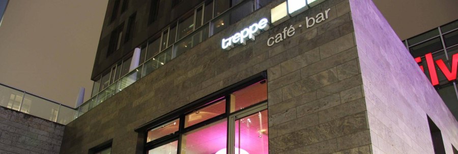 Modernes Gebäude mit der Aufschrift 'treppe café · bar' und beleuchteten Fenstern in der Nacht., © Café Treppe, Stuttgart