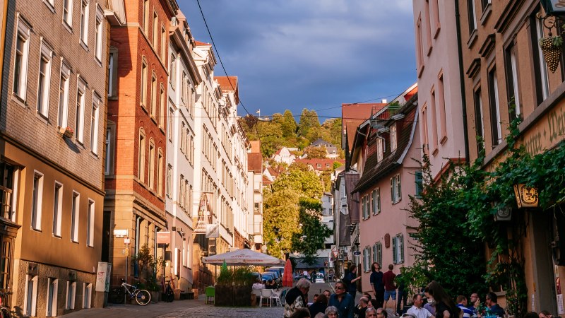 Straßenszene im Bohnenviertel mit historischen Gebäuden, Menschen in Straßencafés und grünem Laub. Die Abendsonne beleuchtet die Fassaden., © SMG Thomas Niedermüller Straßenszene im Bohnenviertel mit historischen Gebäuden, Menschen in Straßencafés und grünem Laub. Die Abendsonne beleuchtet die Fassaden., © SMG Thomas Niedermüller