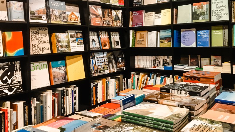 Bücherregale in einer Buchhandlung mit einer Vielzahl von Büchern zu Architektur und Kunst. Stapel von Büchern auf einem Tisch in der Mitte., © Walther König Bücherregale in einer Buchhandlung mit einer Vielzahl von Büchern zu Architektur und Kunst. Stapel von Büchern auf einem Tisch in der Mitte., © Walther König