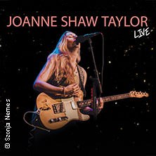 Joanne Shaw Taylor spielt Gitarre und singt auf der Bühne, umgeben von einem dunklen Hintergrund. Der Text "LIVE" ist sichtbar., © links im Bild Joanne Shaw Taylor spielt Gitarre und singt auf der Bühne, umgeben von einem dunklen Hintergrund. Der Text "LIVE" ist sichtbar., © links im Bild