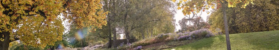 A couple is sitting on a meadow in Rosenstein Park, surrounded by autumnal trees and flowers. The sun is shining through the leaves., &copy; SMG, Christoph D&uuml;pper