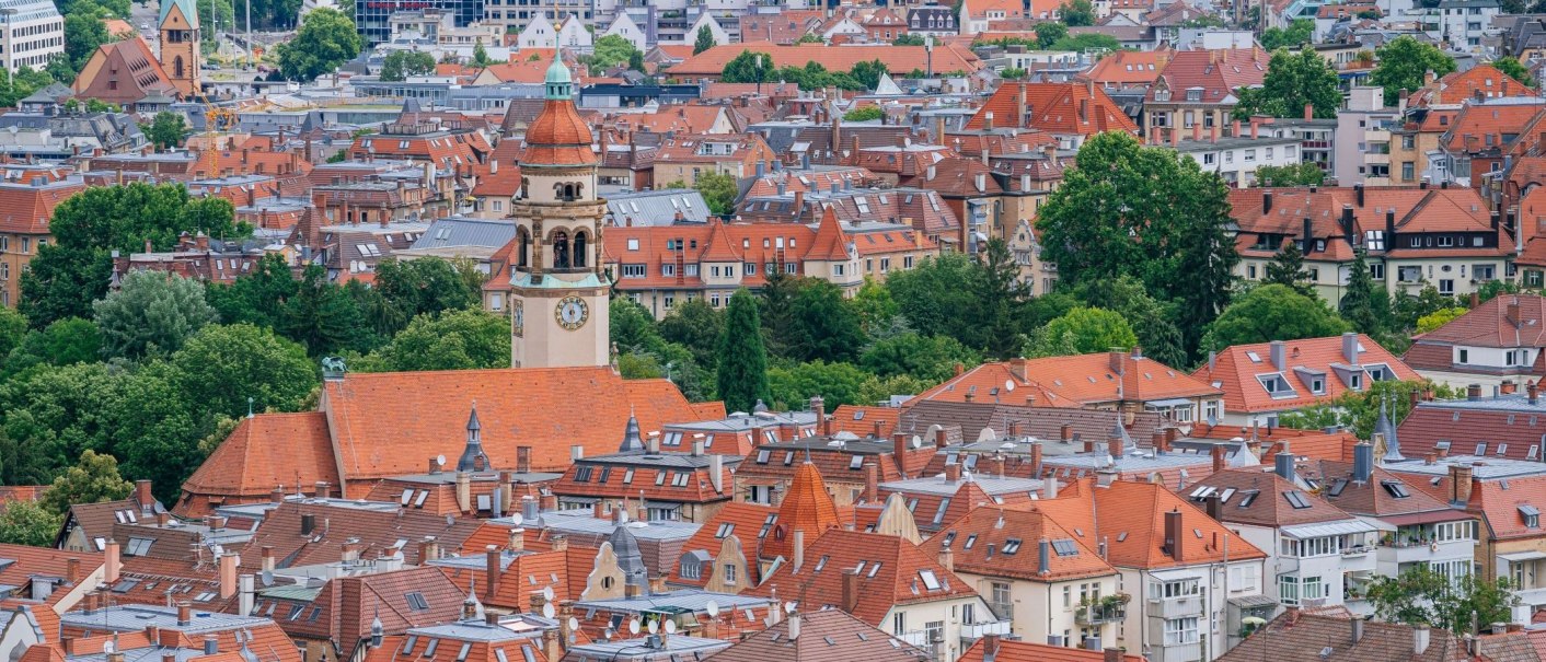 Blick über die Dächer von Stuttgart mit roten Ziegeln und einem markanten Kirchturm, umgeben von grünen Bäumen., © Thomas Niedermüller Blick über die Dächer von Stuttgart mit roten Ziegeln und einem markanten Kirchturm, umgeben von grünen Bäumen., © Thomas Niedermüller