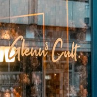 Fensterscheibe eines Cafés mit dem Schriftzug 'Glenn's Cult' und Angeboten wie Aperitivo, Lunch, Tapas, Coffee, Drinks, Vino, Spirits., © SMG, Sarah Schmid Fensterscheibe eines Cafés mit dem Schriftzug 'Glenn's Cult' und Angeboten wie Aperitivo, Lunch, Tapas, Coffee, Drinks, Vino, Spirits., © SMG, Sarah Schmid