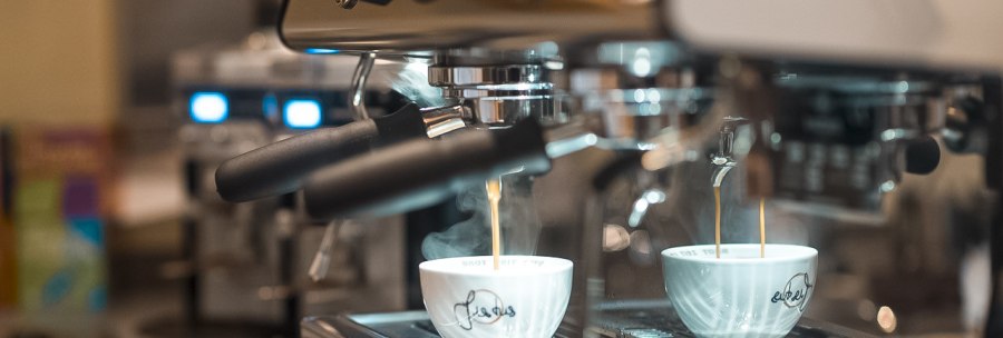 An espresso machine brews fresh coffee in two white cups. The coffee flows into the cups in a thin stream., © Café Justus, Stuttgart