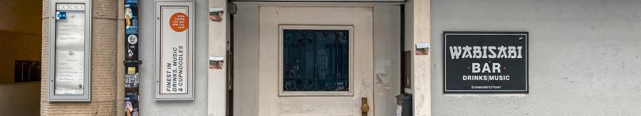Außenansicht der Wabisabi Bar mit Eingangstür, Schildern und der Hausnummer 43. Die Bar bietet Drinks, Musik und Cup Noodles an., © SMG Außenansicht der Wabisabi Bar mit Eingangstür, Schildern und der Hausnummer 43. Die Bar bietet Drinks, Musik und Cup Noodles an., © SMG