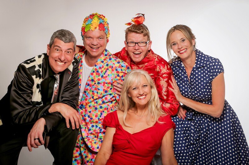 Five people in colorful, eye-catching outfits pose cheerfully for a group photo. They are wearing colorful and patterned clothing., &copy; Theaterhaus Stuttgart e.V.