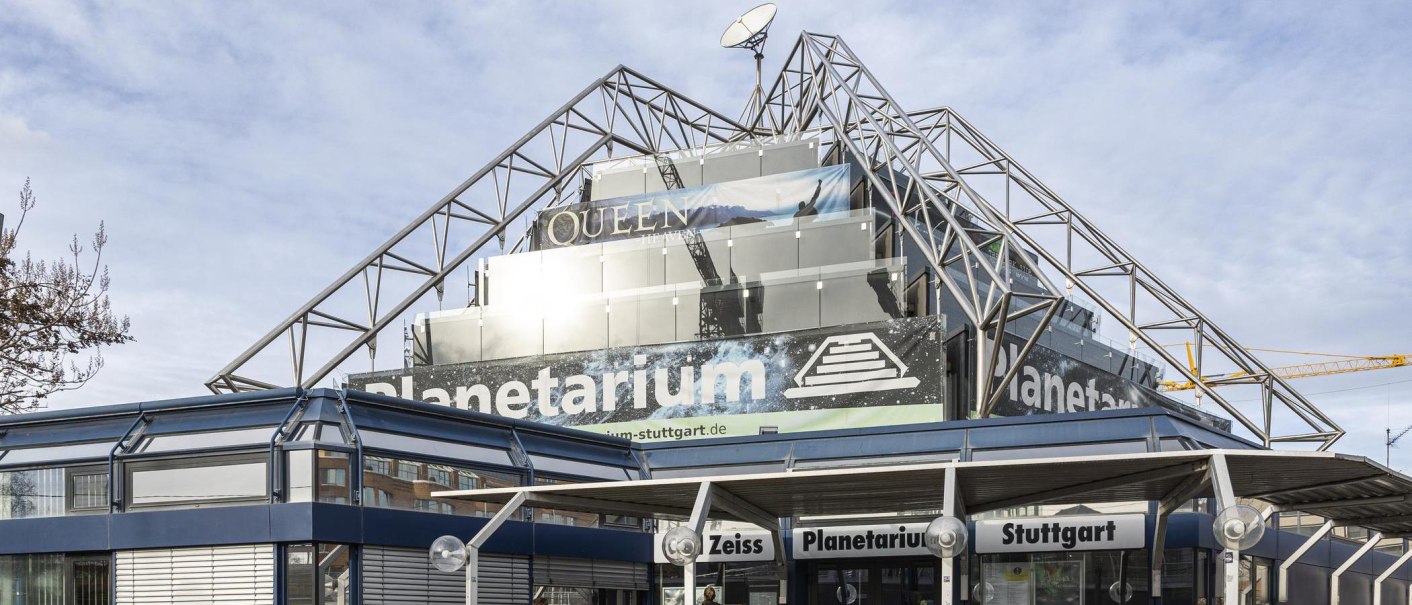 Das Carl-Zeiss Planetarium Stuttgart mit moderner Glas- und Stahlarchitektur, Werbebanner und klarem Himmel im Hintergrund., © Stuttgart-Marketing GmbH, Sarah Schmid Das Carl-Zeiss Planetarium Stuttgart mit moderner Glas- und Stahlarchitektur, Werbebanner und klarem Himmel im Hintergrund., © Stuttgart-Marketing GmbH, Sarah Schmid