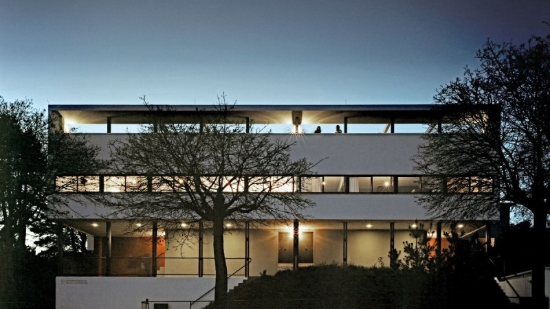 Modernes Geb&auml;ude der Weissenhofsiedlung bei D&auml;mmerung, beleuchtet. Klare Linien und gro&szlig;e Fenster pr&auml;gen die Architektur., &copy; Brigida Gonzalez
