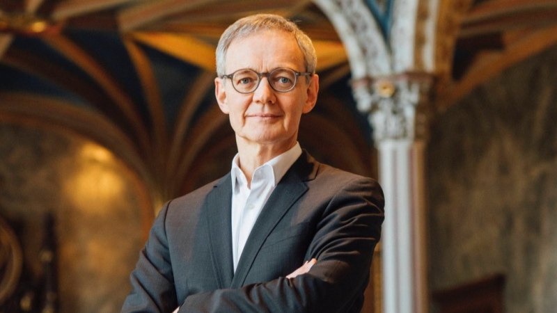 Ein Mann in Anzug und Brille steht selbstbewusst in einem prunkvollen Raum mit verzierten S&auml;ulen und einem kunstvollen Gew&ouml;lbe., &copy; Maria Woerz