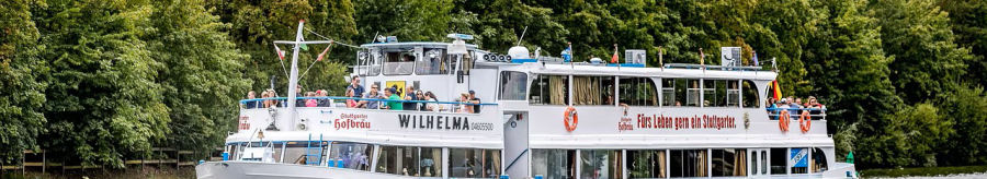 Das Ausflugsschiff f&auml;hrt auf einem Fluss, umgeben von &uuml;ppigem Gr&uuml;n. An Bord sind viele Passagiere, die die Aussicht genie&szlig;en., &copy; NeckarFlair MS Wilhelma Betriebsgesellschaft mbH