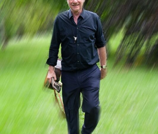 Ein älterer Mann in schwarzer Kleidung geht über eine Wiese. Der Hintergrund ist verschwommen, was Bewegung suggeriert., © Theaterhaus Stuttgart e.V. Ein älterer Mann in schwarzer Kleidung geht über eine Wiese. Der Hintergrund ist verschwommen, was Bewegung suggeriert., © Theaterhaus Stuttgart e.V.