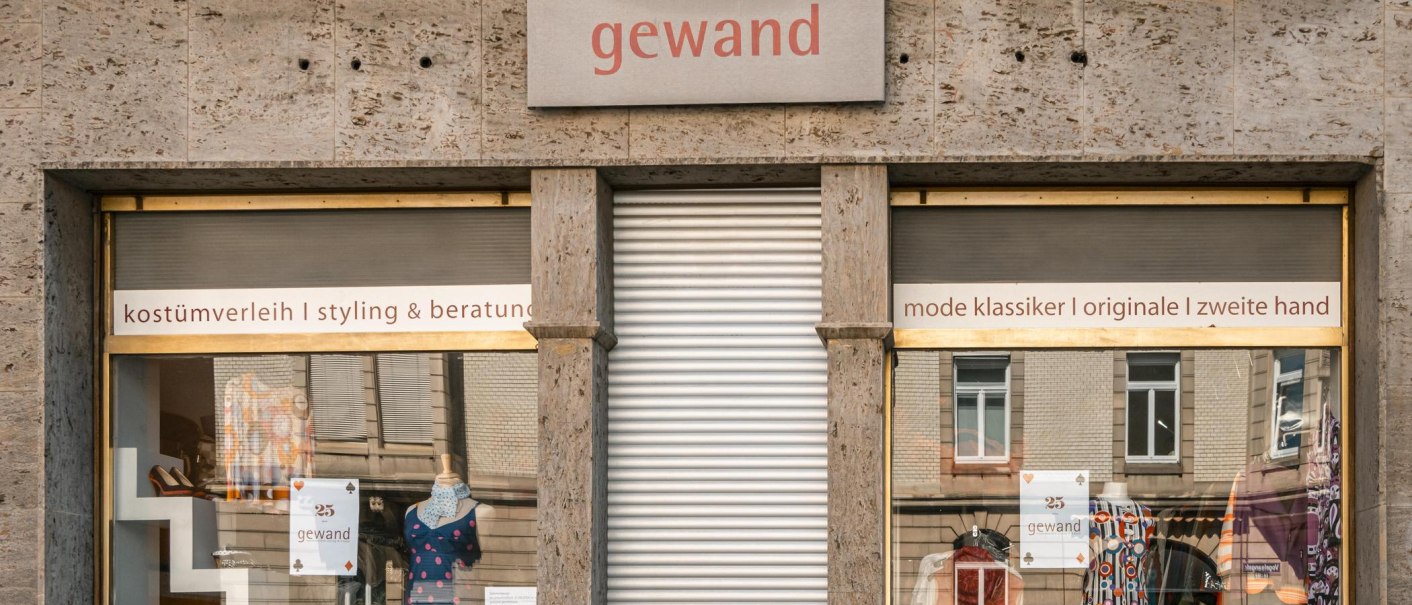 Schaufenster des Ladens 'gewand' mit bunten Kleidern und Accessoires. Schilder weisen auf Kostümverleih, Styling und Second-Hand-Mode hin., © SMG, Sarah Schmid Schaufenster des Ladens 'gewand' mit bunten Kleidern und Accessoires. Schilder weisen auf Kostümverleih, Styling und Second-Hand-Mode hin., © SMG, Sarah Schmid