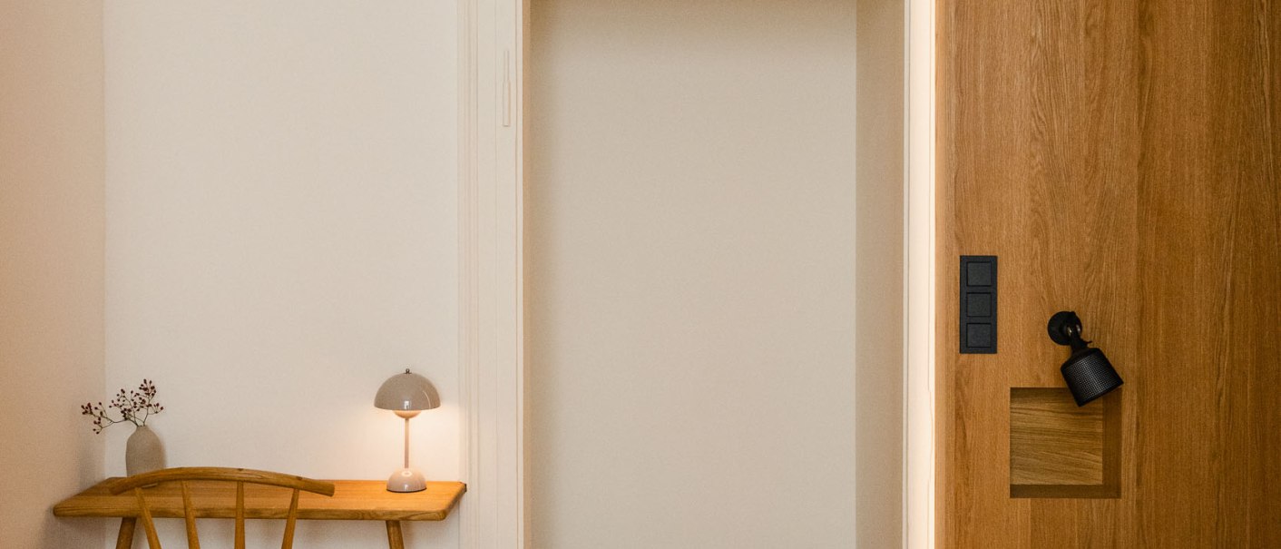 Minimalistisches Zimmer mit Holzboden, kleinem Tisch und Stuhl, Lampe, Bett mit Holzverkleidung. Schlichte, helle Einrichtung., &copy; Peter Oliver Wolff / DAS EDITH