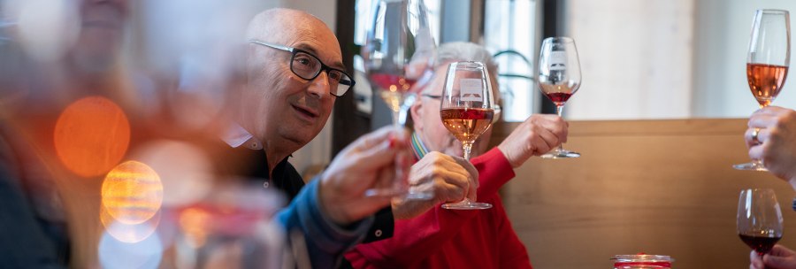Eine Gruppe von Menschen st&ouml;&szlig;t mit Weingl&auml;sern an, w&auml;hrend sie an einem Tisch mit Kerzenlicht und Snacks sitzen., &copy; Stuttgart-Marketing GmbH, Thomas Niederm&uuml;ller