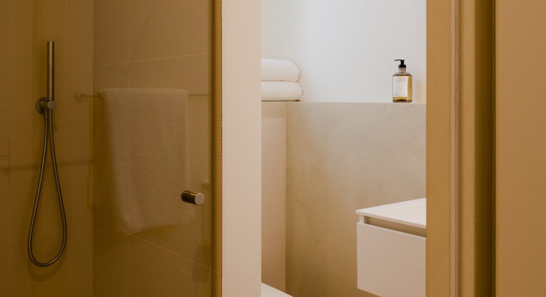 Modernes Badezimmer mit Glasdusche, Toilette und Waschbecken. Handt&uuml;cher und Seifenspender sind vorhanden. Minimalistisches Design in warmen T&ouml;nen., &copy; Peter Oliver Wolff / DAS EDITH