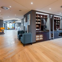 Modern lounge with wooden floor, blue armchairs and yellow chairs. A coffee station and decorative pictures on the wall., © Premier Inn Modern lounge with wooden floor, blue armchairs and yellow chairs. A coffee station and decorative pictures on the wall., © Premier Inn