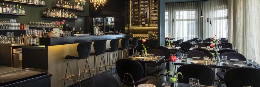 Elegantes Restaurant mit stilvoller Bar, modernen Leuchten und gedeckten Tischen. Tulpen als Dekoration, gem&uuml;tliche Atmosph&auml;re., &copy; Stuttgart-Marketing GmbH, Sarah Schmid