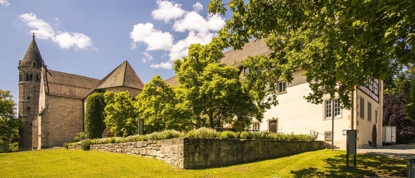 Lorch Abbey set against a sunny landscape with green trees and a clear blue sky in the background., © SMG Stuttgart Marketing GmbH - Sarah Schmid Lorch Abbey set against a sunny landscape with green trees and a clear blue sky in the background., © SMG Stuttgart Marketing GmbH - Sarah Schmid