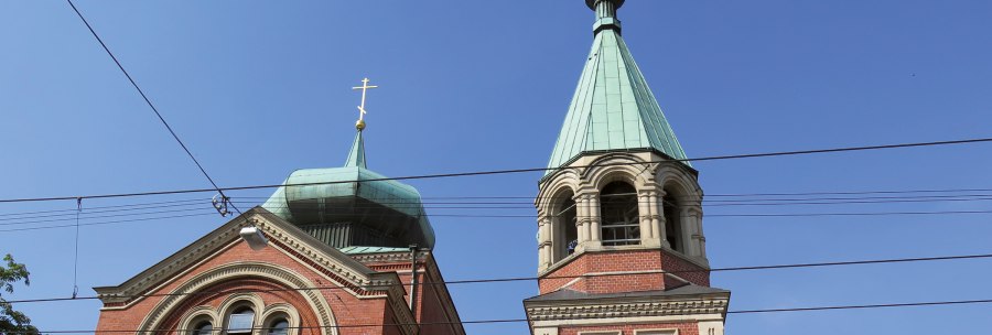 Two steeples of the Russian church of St. Nicholas with blue roofs and golden crosses against a clear sky., &copy; SMG