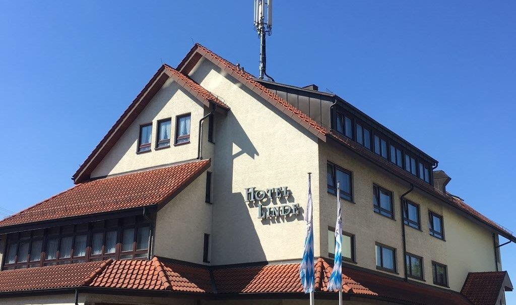 The Neo Hotel Linde in Esslingen with red tiled roof and antenna on the roof against a blue sky., © TOMAS