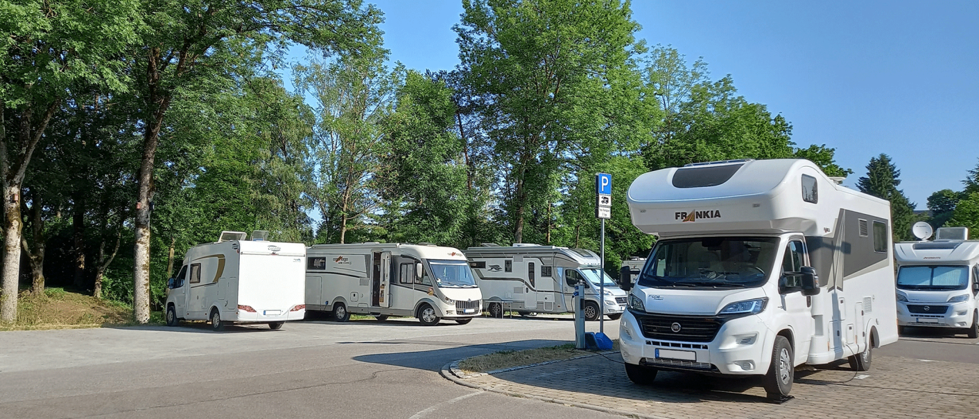 Wohnmobilstellplatz in Gaildorf mit mehreren geparkten Wohnmobilen unter Bäumen an einem sonnigen Tag., © Stadt Gaildorf Wohnmobilstellplatz in Gaildorf mit mehreren geparkten Wohnmobilen unter Bäumen an einem sonnigen Tag., © Stadt Gaildorf