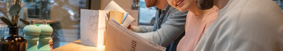 Drei Personen sitzen an einem Tisch in einem Restaurant und lesen die Speisekarte. Im Hintergrund ist ein Fenster mit Blick nach draußen., © Stuttgart-Marketing GmbH, Martina Denker