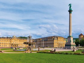 Der Schlossplatz in Stuttgart mit dem Neuen Schloss, der Jubiläumssäule und Brunnen. Menschen spazieren und entspannen auf dem grünen Platz., © SMG