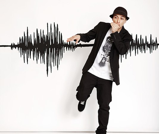 Ein Beatboxer posiert vor einer Wand mit Schallwellen-Grafik, trägt einen Hut und hält die Hand vor den Mund. Er ist lässig gekleidet in Schwarz-Weiß., © Renitenztheater Stuttgart e.V. Ein Beatboxer posiert vor einer Wand mit Schallwellen-Grafik, trägt einen Hut und hält die Hand vor den Mund. Er ist lässig gekleidet in Schwarz-Weiß., © Renitenztheater Stuttgart e.V.