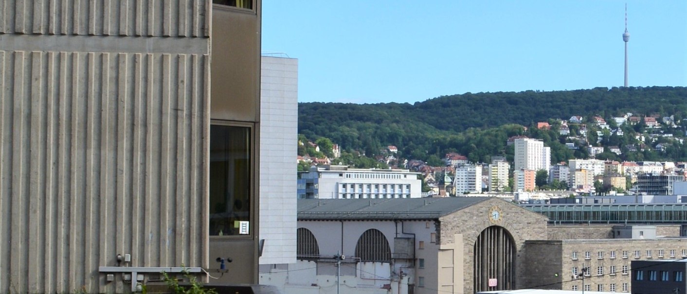Stadtansicht mit Geb&auml;uden, einem Kran und einem Turm im Hintergrund. Im Vordergrund ein begr&uuml;ntes Dach., &copy; Hotel BaW&uuml;