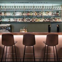 Moderne Bar mit hohen St&uuml;hlen, beleuchtetem Tresen und Flaschenregal im Hintergrund. Dezente Beleuchtung und schlichte Einrichtung., &copy; Eduards Bar, Stuttgart