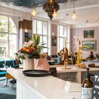 Cozy caf&eacute; with flowers and pretzels on the counter, blue sofas and art on the walls. Large windows let in plenty of light., &copy; SMG Stuttgart Marketing GmbH - Sarah Schmid