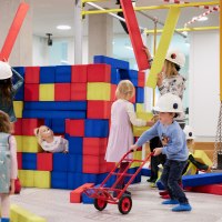 Children play on an indoor construction site with colorful foam blocks. They wear construction helmets and have fun building and playing., © Julia Ochs Children play on an indoor construction site with colorful foam blocks. They wear construction helmets and have fun building and playing., © Julia Ochs