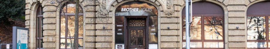 A historic building with the lettering 'Brother Louis' above the front door. The façade is made of stone with decorative elements., © Stuttgart-Marketing GmbH, Sarah Schmid A historic building with the lettering 'Brother Louis' above the front door. The façade is made of stone with decorative elements., © Stuttgart-Marketing GmbH, Sarah Schmid