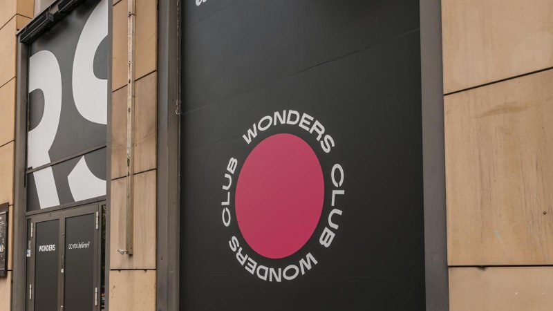 Eingang des Wonders Club mit großem Logo und Schriftzug an der Fassade. Schwarze Türen und ein pinker Kreis mit dem Text 'Wonders Club'., © Stuttgart Marketing GmbH, Sarah Schmid Eingang des Wonders Club mit großem Logo und Schriftzug an der Fassade. Schwarze Türen und ein pinker Kreis mit dem Text 'Wonders Club'., © Stuttgart Marketing GmbH, Sarah Schmid