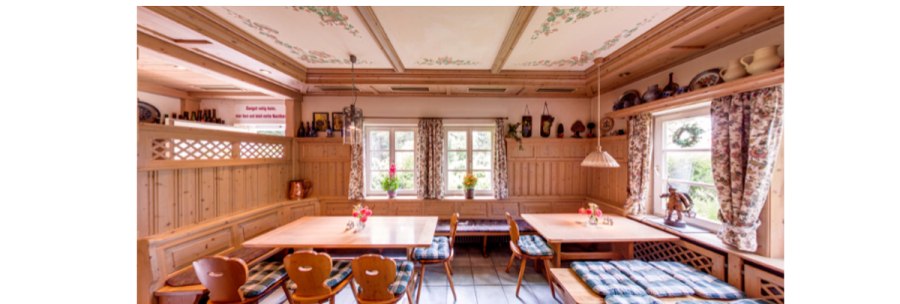 A cozy dining room with wooden furniture, checkered seat cushions and floral curtains. There are floral patterns on the ceiling and ceramics on shelves., &copy; Weingut Karl W&ouml;hrwag