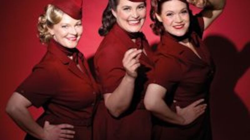 Drei Frauen in roten Retro-Kleidern und Hüten posieren lächelnd vor rotem Hintergrund., © Altes Schauspielhaus und Komödie im Marquardt e.V. Drei Frauen in roten Retro-Kleidern und Hüten posieren lächelnd vor rotem Hintergrund., © Altes Schauspielhaus und Komödie im Marquardt e.V.