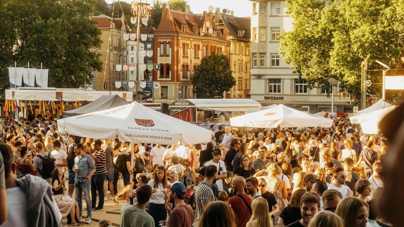 Ein belebtes Stadtfest auf dem Marienplatz mit vielen Menschen, St&auml;nden und Sonnenschirmen bei sonnigem Wetter., &copy; Stuttgart-Marketing GmbH, Alwin Maigler