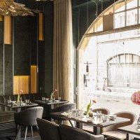 Elegantes Restaurant mit modernen Möbeln, großen Fenstern und stilvoller Dekoration. Draußen sind rote Motorroller zu sehen., © Stuttgart-Marketing GmbH, Sarah Schmid Elegantes Restaurant mit modernen Möbeln, großen Fenstern und stilvoller Dekoration. Draußen sind rote Motorroller zu sehen., © Stuttgart-Marketing GmbH, Sarah Schmid