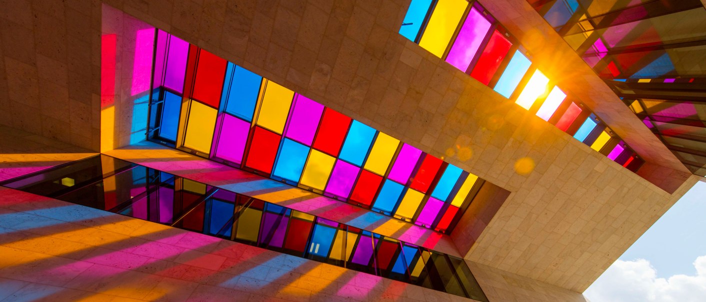 Stained glass windows in a modern building cast colorful shadows on the walls. Sunlight shines through the windows., © © Stuttgart-Marketing GmbH Stained glass windows in a modern building cast colorful shadows on the walls. Sunlight shines through the windows., © © Stuttgart-Marketing GmbH