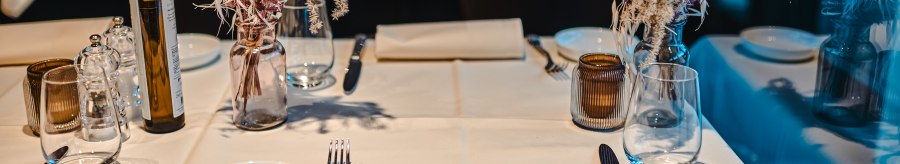 An elegantly laid table in a restaurant with white tablecloths, flower arrangements, glasses and cutlery., © Feinkost Böhm GmbH An elegantly laid table in a restaurant with white tablecloths, flower arrangements, glasses and cutlery., © Feinkost Böhm GmbH