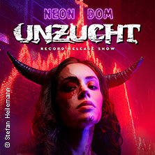 Eine Frau mit H&ouml;rnern steht vor einem roten, neonbeleuchteten Hintergrund. Oben steht der Schriftzug 'Unzucht - Neon Dom Record Release Show'., &copy; links im Bild